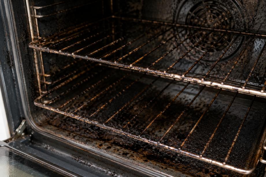 Dirty oven racks with heavy carbon and grease buildup inside oven
