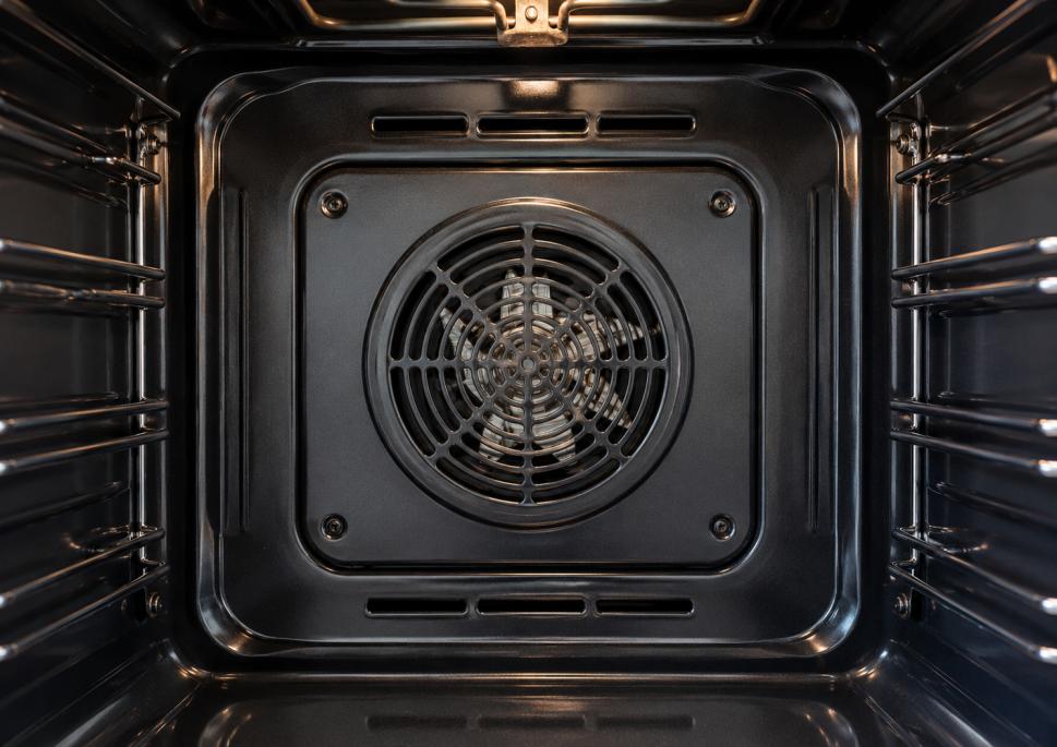 Close-up of the rear oven fan area during a professional deep oven cleaning process.